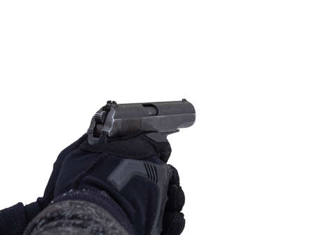 A male police officer in tactical black gloves holds a gun in his hands. The concept of criminal offense, robbery, murder, terrorist act, sports shooting.の写真素材