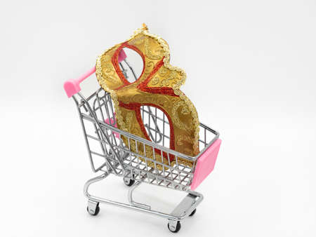Traditional gold carnival mask toy mini shopping cart (trolley) on a white background. The concept of preparing for the annual Brazilian festival, buying costumes.の写真素材