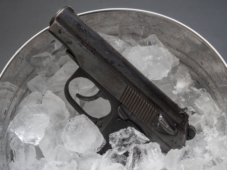 Police 9mm pistol frozen in a bucket with crushed ice cubesの写真素材