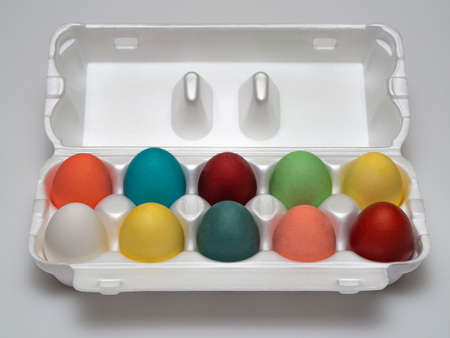 Multicolored colored, boiled chicken eggs in factory, store-made expanded polystyrene packaging,...