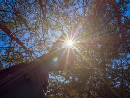 A man shows a like or thumbs up sign in the sun. Contour sunlight. The concept of global signs and...