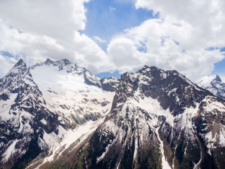 A landscape with a view of a mountain snow-covered peak. Travel, tourism to the Caucasus Mountains, Dombay. The concept of wildlife without a trace of humans.の写真素材