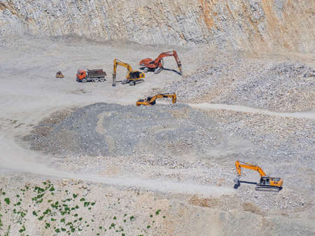 Many industrial excavators, earthmoving machines extract cement and marl rock in the mountains of...
