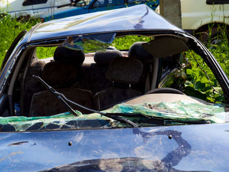 A automobile wrecked in an accident. Detailed photo of the damage to the black car. Transport at the disassembly station.の写真素材
