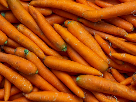 Background of washed orange carrots without green tops close-up in full screen. Autumn harvest...