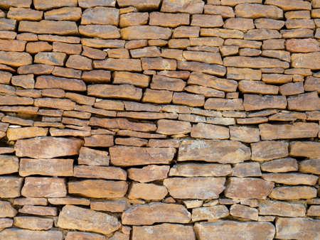 The texture of ancient historical masonry wall made of different sizes of stones without the use of cement.の写真素材