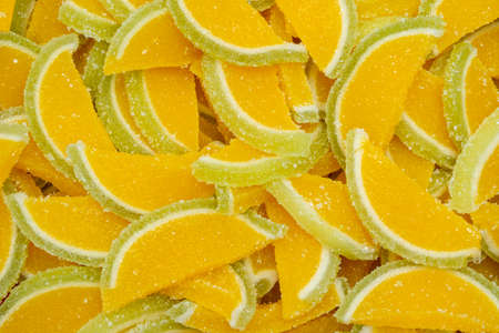 The background of the marmalade is citrus orange slices in full screen. Sweets with sugar on the...