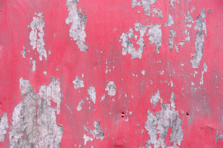 The texture of a pink iron wall with peeling paint.With an old metal shabby wall.の写真素材