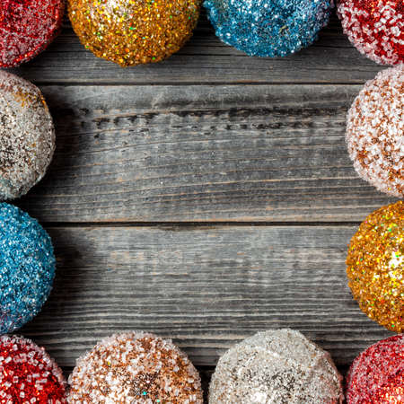Frame and copy space of shiny multicolored Christmas decoration balls on a wooden background of a gray table.の写真素材