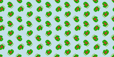 Seamless pattern Christmas ginger cookies in the shape of a green mittens with a Christmas tree on a green pastel background.の写真素材