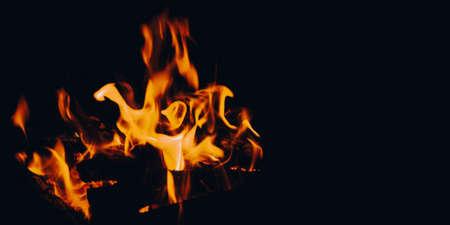 Burning wood in a campfire close-up. Selective focus. Charcoal in a bright red flame. Flashes and sparks in the fire of a forest fire. The concept of warmth and comfort.の写真素材