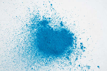 A pile of a sample of blue dry dye or powder on a white background.の写真素材