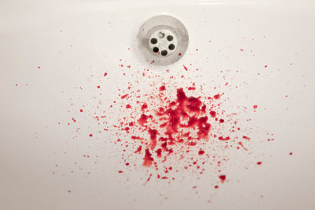 Drops of blood on the white ceramic sink in the bathroom close up. The concept of home injury, nosebleeds, toothache.の写真素材