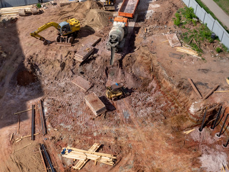 Empty construction site with truck, tractor and excavator and concrete mixer machine with aerial...