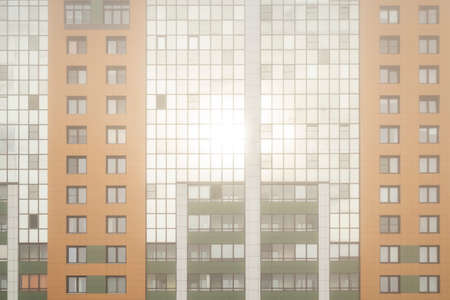 Multi storey residential buildings in the morning fog and the rays of the dawn sun. The texture or...