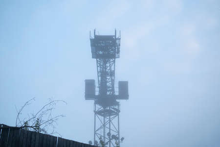 Mystical landscape of a construction old crane in a dense morning fog. Pollution and smog on the...