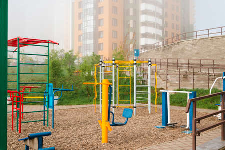 Morning fog on a bright colorful playground in a residential area.