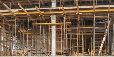 Scaffolding on the construction site, bottom view. The frame of the facade of a building under...