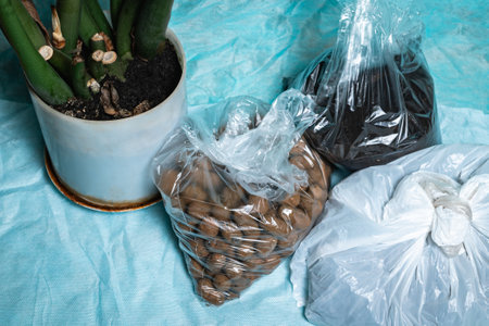 Prepared earth, expanded clay and a new flower pot for transplanting plants. The concept of a domestic hobby.の写真素材