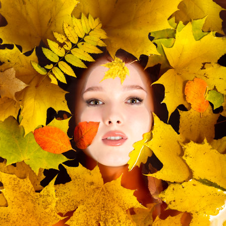 A woman lies in colored black water with autumn leaves. The concept of aromatherapy and relaxation.の写真素材