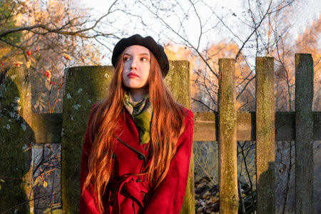 A young woman in a red coat in the autumn forest.の写真素材