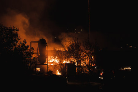 A large scale night fire at a factory or sawmill. Fire and smoke close up.の写真素材