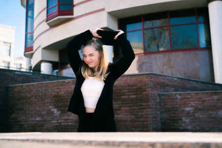 Young female office worker smashes a laptop on the street. An irritated, hysterical businesswoman....