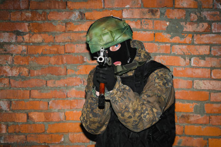 Portrait of a military man with blue eyes in a black balaclava and camouflage. Soldier with assault...
