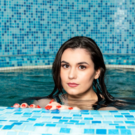 Portrait of a woman swimming in a hot pool or a sauna bath.