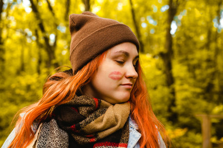 A woman in a cap and scarf, embarrassed by the lipstick mark of a kiss on her cheek.の写真素材