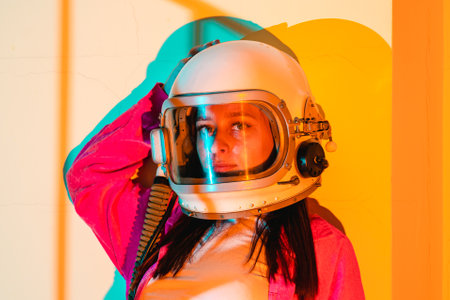 Portrait woman in an astronaut helmet close up on yellow background.の写真素材