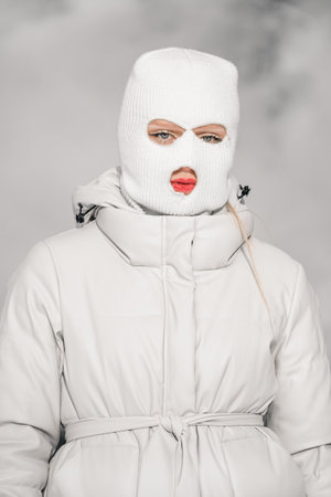 Woman in a white in a winter city with frosty fog on the background.の写真素材