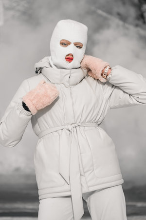 Woman in a white in a winter city with frosty fog on the background.の写真素材