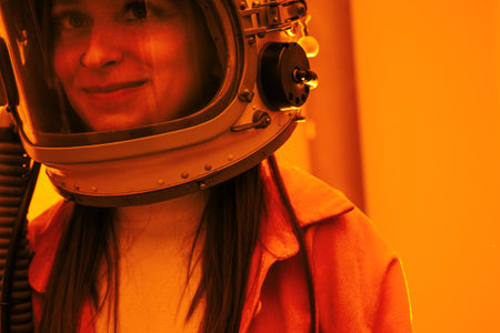 Portrait woman in an astronaut helmet close up on yellow background.の写真素材