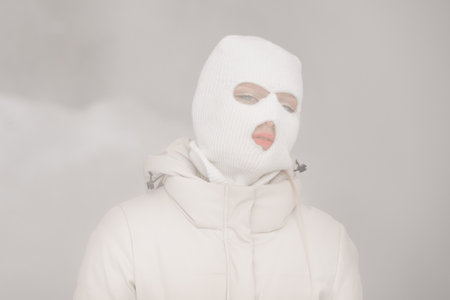 Woman in a white in a winter city with frosty fog on the background.の写真素材