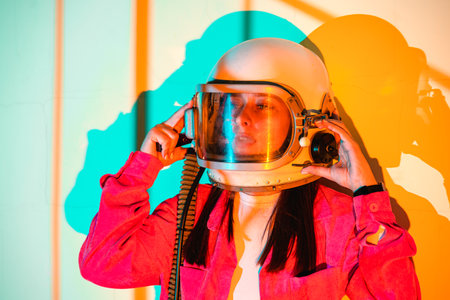 Portrait woman in an astronaut helmet close up on yellow background.