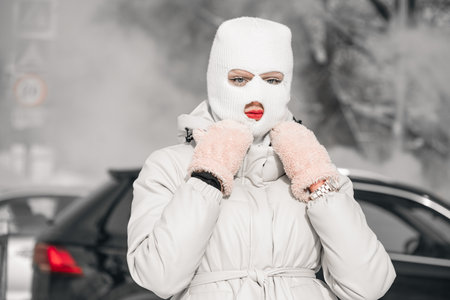Woman in a white in a winter city with frosty fog on the background.の写真素材