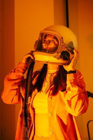 Portrait woman in an astronaut helmet close up on yellow background.