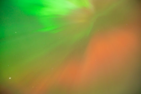 Coronal aurora borealis glowing in the night sky, vibrant green color lights.の写真素材