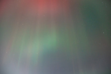 Coronal aurora borealis glowing in the night sky, vibrant green color lights.の写真素材