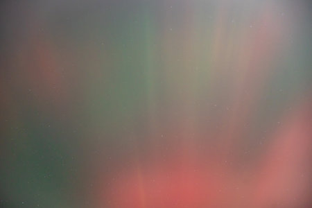 Coronal aurora borealis glowing in the night sky, vibrant green color lights.の写真素材