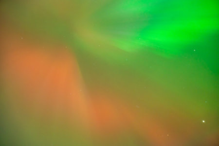 Coronal aurora borealis glowing in the night sky, vibrant green color lights.の写真素材