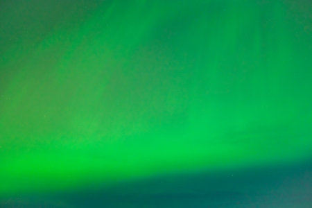 Coronal aurora borealis glowing in the night sky, vibrant green color lights.の写真素材