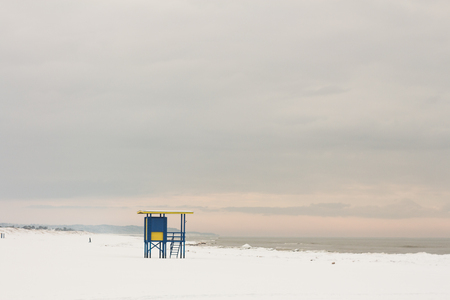Lifeguard tower at the snowy beach with pink clouds, Ventspils, Baltic seaの写真素材