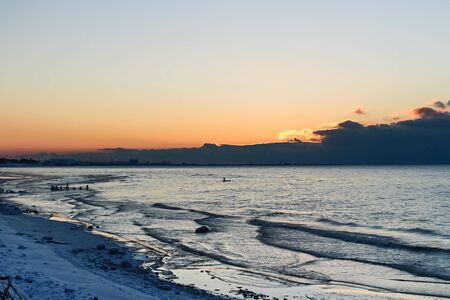 Pink tone of sunset on sky and Baltic sea in winterの写真素材