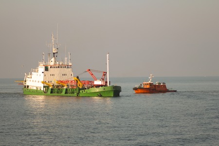Dredger Vessel and pilot boat mooring in open seaの写真素材