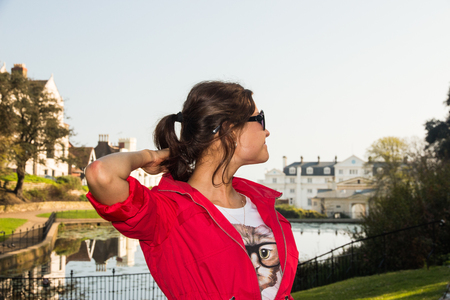 Smiling woman in black sunglasses looks up in the skyの写真素材