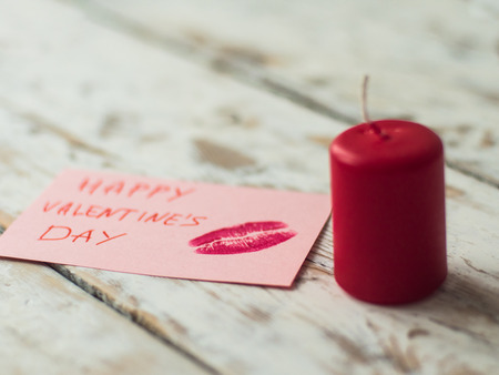 St Valentines decor with red candle and card on wooden backgroundの写真素材