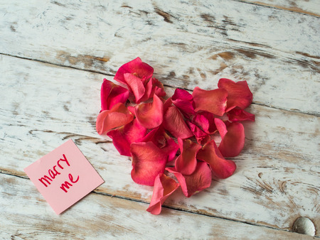 Marry me words written on paper, love card. Valentines Day background, love postcard.の写真素材
