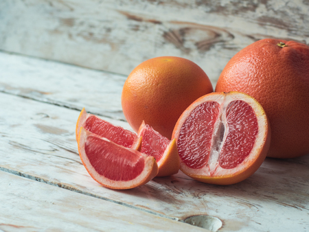 Grapefruit with slices on a wooden table, close upの写真素材